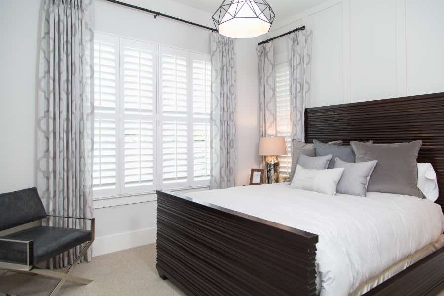 White Polywood shutters on windows in a stylish bedroom